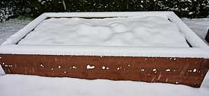 Snow covered raised bed in garden